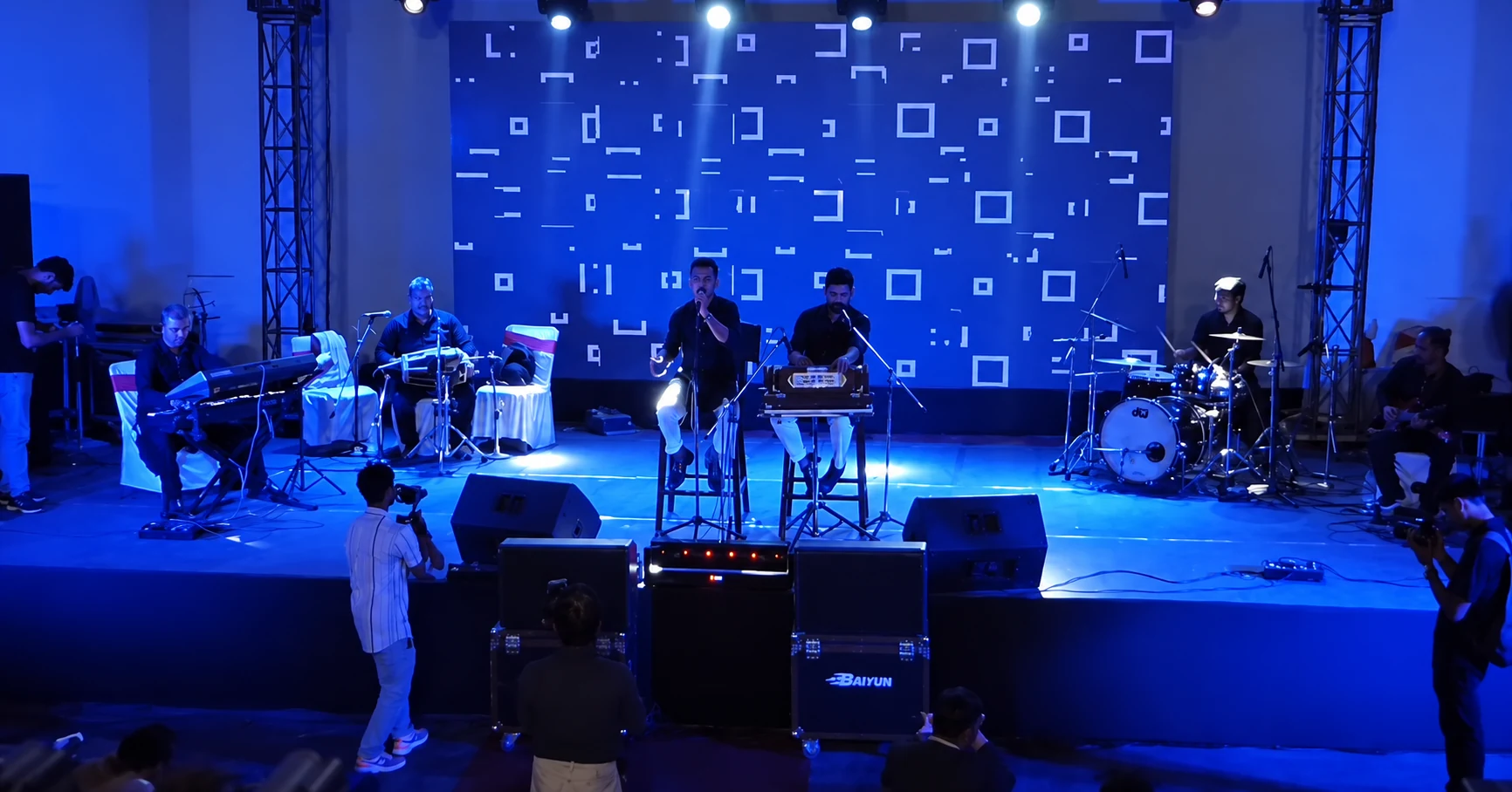 A wide view of the band on the blue-lit stage at C2BE