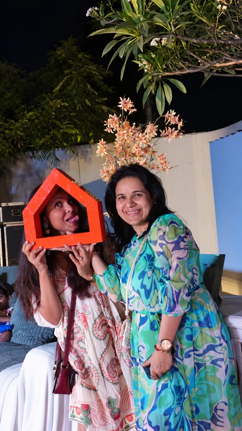 Two guests posing with the physical orange Ashley house-shaped prop