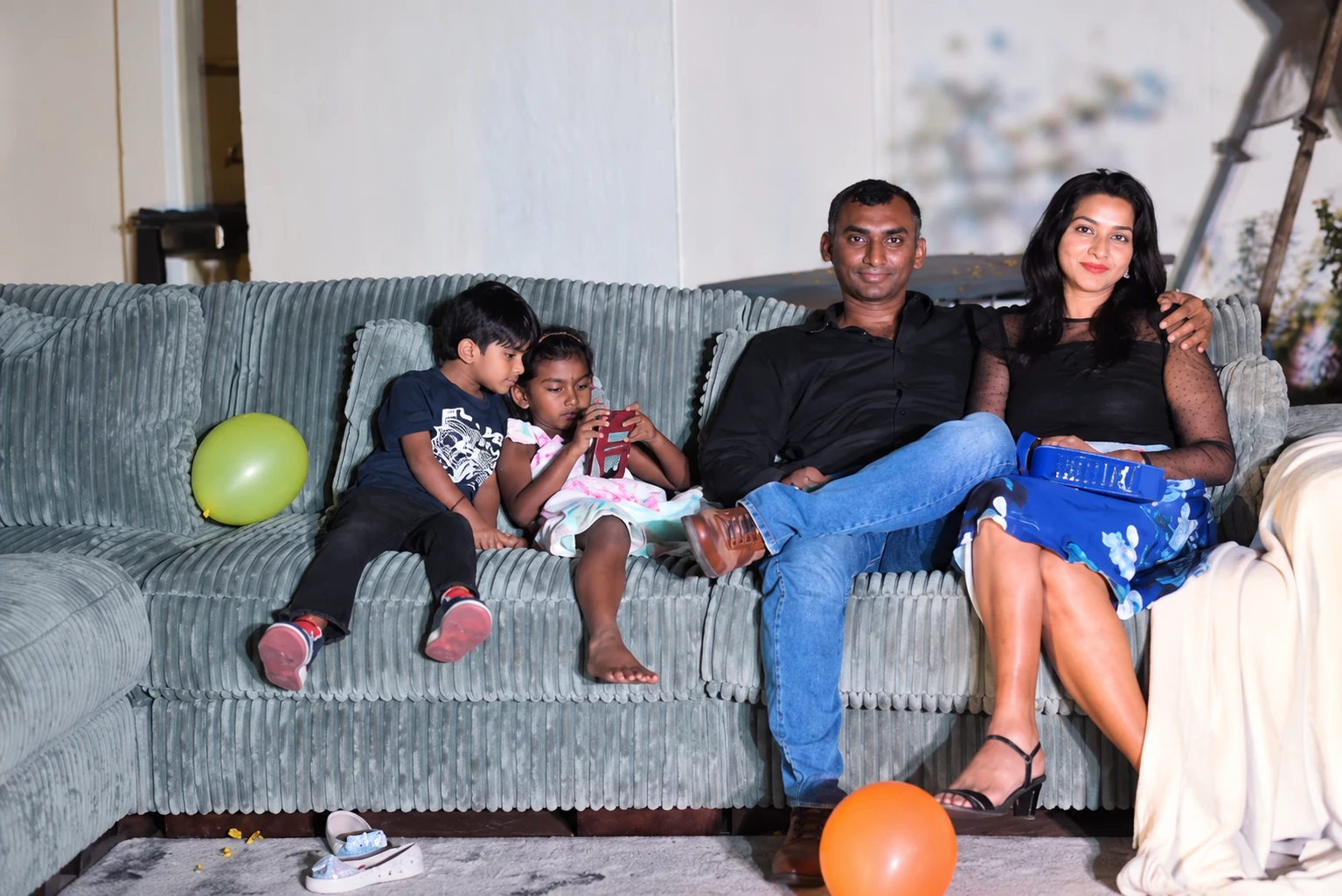 Parents and two children seated together on the Ashley sofa during the pool party
