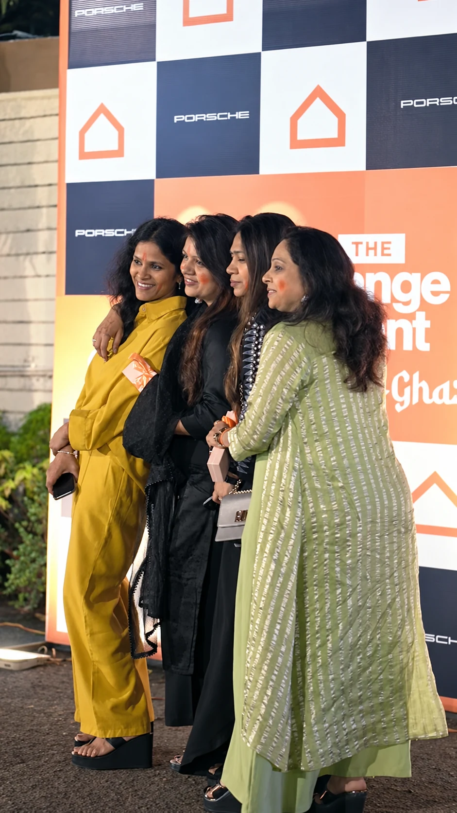 Four women posing in front of the physical Ashley and Porsche event backdrop