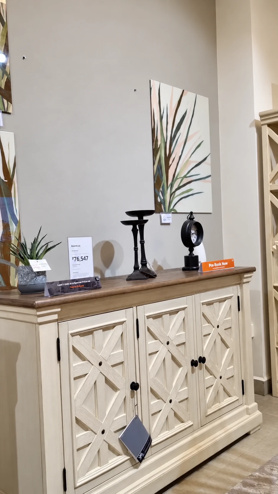 A white and wood sideboard with its price card and a pre-booking offer beside it