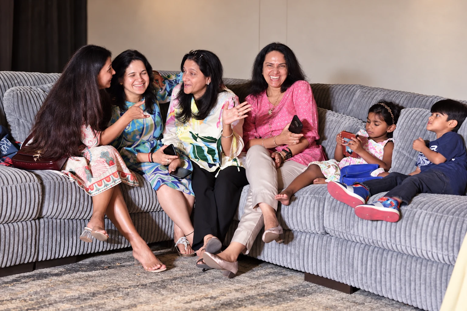 Friends and children sharing an Ashley sofa in a relaxed social setting