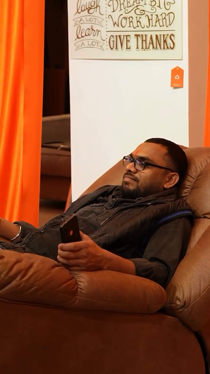 A visitor seated in a brown recliner during the Orange Event showroom tour
